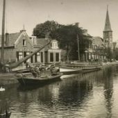 afkomstig van www.dorpsarchiven.nl - Het voorste skûtsje is de 'Hoop op Welvaart'. Hier voor de brug in Woudsend