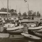 afkomstig van het Fries Scheepvaartmuseum - Rechts het schip van Gerrit Witteveen, op het helmhout zittend bij het skûtsjesilen. Hier liggend aan de Finne in Grou, 1930