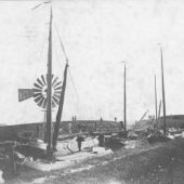 afkomstig van Tresoar - Skûtsjes afgemeerd bij de laadplaats van de Burmaniaterp te Ferwerd. Op het voorste skûtsje staan schipper S. Kok en zijn vrouw, 1908